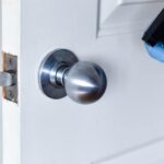 Lubricating a car door lock mechanism with silicone spray, ensuring smooth operation